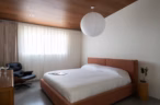 Arapaho property bedroom with modern bed, lounge chair, and pendant light