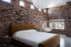 Arapaho property bedroom with brick walls, modern bed, and hanging chair