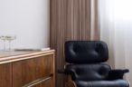 Arapaho property interior with black lounge chair and wooden dresser