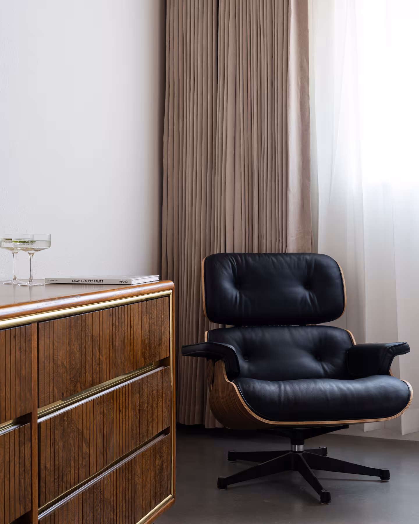 Arapaho property interior with black lounge chair and wooden dresser