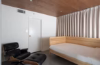 Arapaho property minimalist bedroom with wooden bed and lounge chair