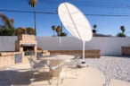 Arapaho property outdoor dining area with round table, chairs, and brick grill