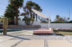 Arapaho property poolside area with sun loungers and palm trees