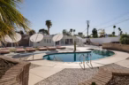 Arapaho property poolside view with lounge chairs, umbrellas, and backyard